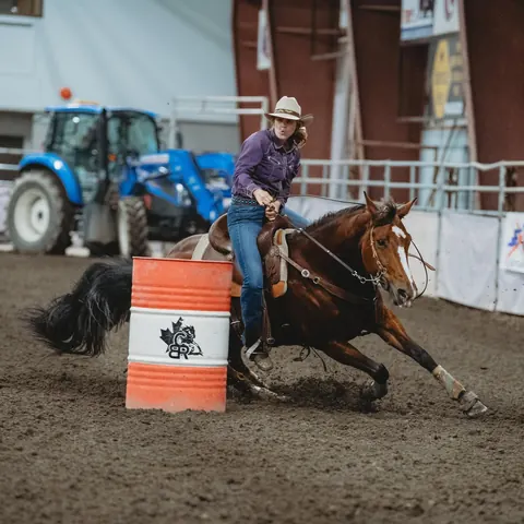 Alyssa and Pushy turning a barrel in an outdoor arena